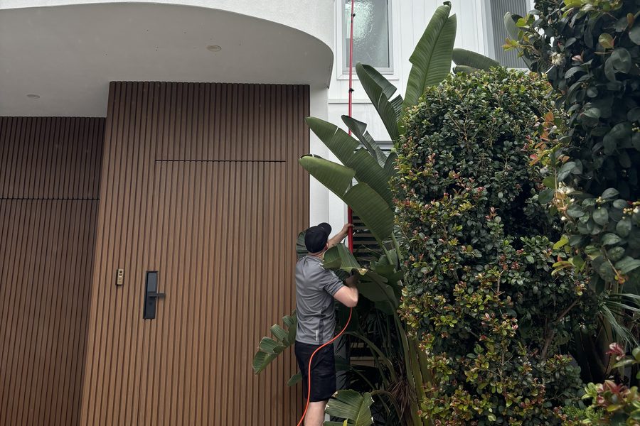 Gabor using a water fed pole to reach an upper storey window on a two storey Sydney home