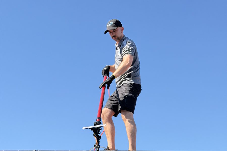 Gabor brushing rooftop solar panels with a water fed brush under clear sky